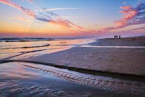 atlantisch Ozean Sonnenuntergang mit wogend Wellen beim fonte da telha Strand, Portugal foto