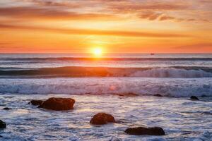 atlantisch Ozean Sonnenuntergang mit Wellen und Felsen. Costa da Caparica, Portugal foto