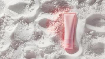 ein Rosa Hautpflege Tube Lügen im Weiß Sand. foto