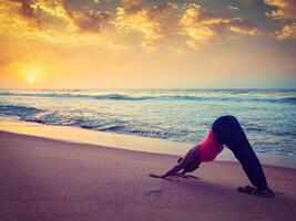 jung sportlich passen Frau tun Yoga beim Strand auf Sonnenuntergang foto