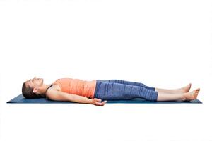 sportlich Frau entspannt sich im Yoga Asana Savasana foto