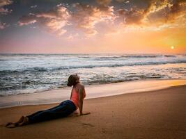 Frau Praktiken Methoden Ausübungen Yoga Asana urdhva Mukha svanasana beim das Strand foto