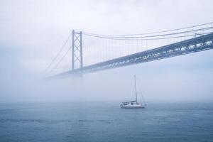 Aussicht von 25 de Abril Brücke berühmt Tourist Wahrzeichen von Lissabon im schwer Nebel Nebel foto