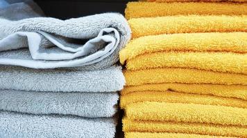 Stapel flauschiger Badetücher in verschiedenen Farben in einem Schaufenster. Frottee-Handtücher in einem Stapel in den Regalen eines Supermarkts. foto