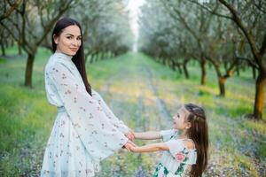 ein glücklich Familie. Mutter und Tochter sich ausruhen im das Park im Kleider foto