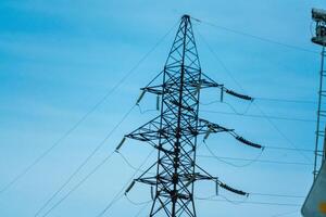 hoch Stromspannung Türme mit Himmel Hintergrund. Leistung Linie Unterstützung mit Drähte zum Elektrizität Übertragung. hoch Stromspannung Gitter Turm mit Draht Kabel beim Verteilung Bahnhof. Energie Industrie, Energie Speichern foto