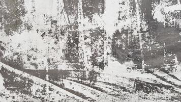 verwitterte und gealterte Betonwand mit Farbe, meist schwarz und weiß mit Vignettierung abgeschält. Grau- und Weißtöne. großer moderner, strukturierter Hintergrund. abstrakter alter Hintergrund foto