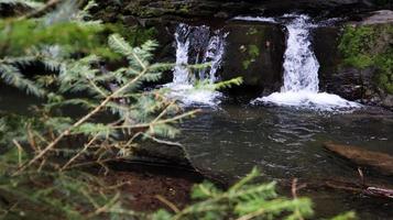 Wasserfälle in einer kleinen Schlucht mit Steinwänden. schöne Kaskade in den Bergen. Fluss in den Karpaten im Bergherbstwald. malerische Aussicht, die Bewegung des Wassers. foto