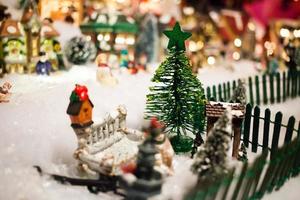 Miniatur-Weihnachtsdorf unter Weihnachtsbaum foto