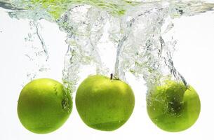 eine Reihe, grüne Äpfel im Wasser foto