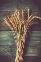 Weizenähren auf dem Holztisch. Garbe Weizen über Holz Hintergrund. Erntekonzept foto