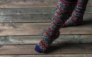 Beine im Farbe Socken auf ein hölzern Fußboden foto