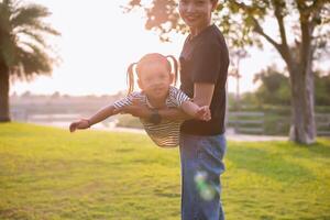 ein Silhouette von ein glücklich jung Mutter harmonisch Familie draußen. Lachen und spielen im das Sommer- auf das Sonnenuntergang Hintergrund.sstkhome foto