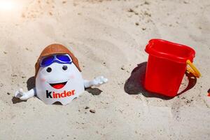 freundlicher Überraschung kinderino Maskottchen Spielzeuge und Paddel im das Sand foto