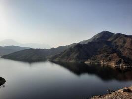 ein schön tagsüber Aussicht von Wadi qanuna Damm im al Bahah, Saudi Arabien. das Wasser von das Damm und das Umgebung Hügel sind präsentieren ein schön Szene im das Sonnenlicht. foto