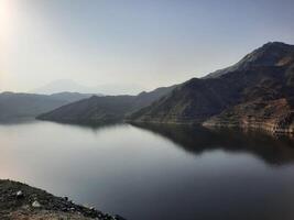 ein schön tagsüber Aussicht von Wadi qanuna Damm im al Bahah, Saudi Arabien. das Wasser von das Damm und das Umgebung Hügel sind präsentieren ein schön Szene im das Sonnenlicht. foto