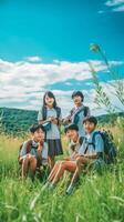 vier süß barfüßig Kinder im Sommer- Kleider Verlegung auf Grün Gras mit schwarz Laptopkopie Raum, generativ ai foto
