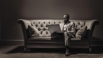 ernst jung afro amerikanisch Mann auf Geschäft Ausflug Sitzung auf rot Leder Sofa im Hotel Empfangshalle mit generisch Laptop Tippen etwas oder Überprüfung Email suchen beim Bildschirm mit konzentrieren, generativ ai foto