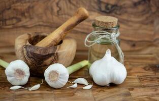 frisch Knoblauch zum Knoblauchöl auf Olive Holz foto