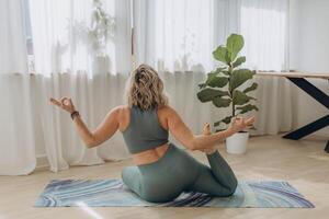 ein 50 Jahre alt Frau tut Yoga beim Zuhause foto