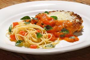 Filet al Parmigiano mit Spaghetti mit gehackt Tomaten foto