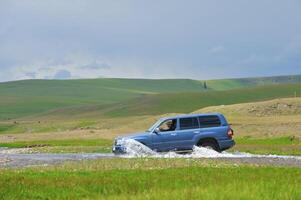 Offroad Auto Kreuzung das Fluss im Berge foto