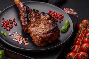 köstlich saftig Rindfleisch Steak auf das Knochen, Tomahawk mit Salz, Gewürze und Kräuter foto