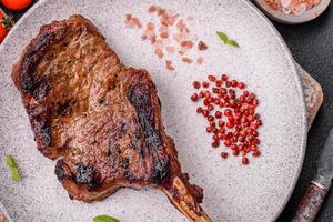 köstlich saftig Rindfleisch Steak auf das Knochen, Tomahawk mit Salz, Gewürze und Kräuter foto