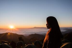 glückliche Frau wacht morgens auf dem Berg auf foto