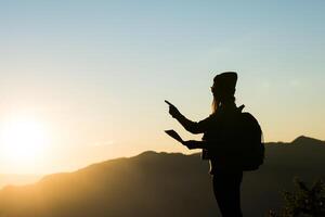 Silhouette der Touristenfrau, die im Berg steht foto