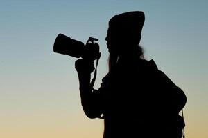 Silhouette der Touristenfrau, die im Berg steht foto