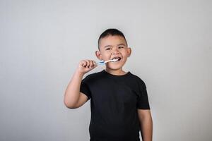 kleiner Junge beim Zähneputzen im Studiofoto foto