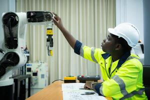 Ingenieure gebaut und geprüft das Funktionalität von ein Roboter Arm verwendet im klein Branchen. foto