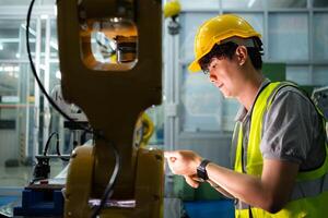 ein Techniker leidet ein Hand Unfall während Arbeiten mit ein Roboter Arm im ein Fabrik mit Mitarbeiter Bereitstellung Hilfe foto