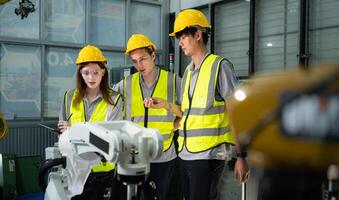 Ingenieur und Techniker diskutieren das Roboter Arm im Fabrik Über Arbeit Betriebs, Instandhaltung und Reparatur foto