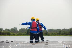 Photovoltaik Ingenieure Arbeit auf schwebend Photovoltaik. prüfen und Reparatur das Solar- Panel Ausrüstung schwebend auf das Wasser. foto