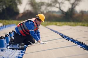 Photovoltaik Ingenieure Arbeit auf schwebend Photovoltaik. prüfen und Reparatur das Solar- Panel Ausrüstung schwebend auf das Wasser. foto