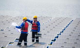 Photovoltaik Ingenieure Arbeit auf schwebend Photovoltaik. prüfen und Reparatur das Solar- Panel Ausrüstung schwebend auf das Wasser. foto