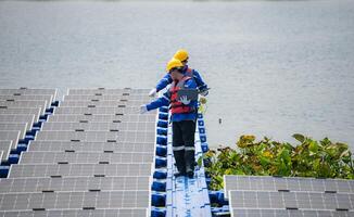 Photovoltaik Ingenieure Arbeit auf schwebend Photovoltaik. prüfen und Reparatur das Solar- Panel Ausrüstung schwebend auf das Wasser. foto