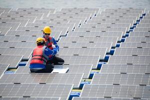 Photovoltaik Ingenieure Arbeit auf schwebend Photovoltaik. prüfen und Reparatur das Solar- Panel Ausrüstung schwebend auf das Wasser. foto