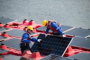 Photovoltaik Ingenieure Arbeit auf schwebend Photovoltaik. prüfen und Reparatur das Solar- Panel Ausrüstung schwebend auf das Wasser. foto