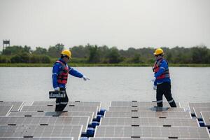 Photovoltaik Ingenieure Arbeit auf schwebend Photovoltaik. prüfen und Reparatur das Solar- Panel Ausrüstung schwebend auf das Wasser. foto