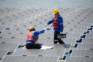 Photovoltaik Ingenieure Arbeit auf schwebend Photovoltaik. prüfen und Reparatur das Solar- Panel Ausrüstung schwebend auf das Wasser. foto