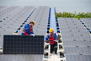 Photovoltaik Ingenieure Arbeit auf schwebend Photovoltaik. prüfen und Reparatur das Solar- Panel Ausrüstung schwebend auf das Wasser. foto