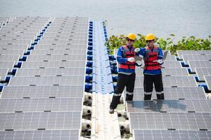 Photovoltaik Ingenieure Arbeit auf schwebend Photovoltaik. prüfen und Reparatur das Solar- Panel Ausrüstung schwebend auf das Wasser. foto
