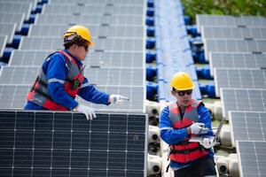 Photovoltaik Ingenieure Arbeit auf schwebend Photovoltaik. prüfen und Reparatur das Solar- Panel Ausrüstung schwebend auf das Wasser. foto