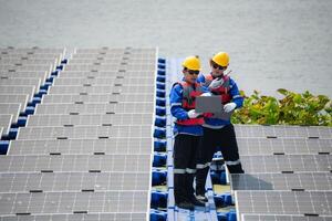 Photovoltaik Ingenieure Arbeit auf schwebend Photovoltaik. prüfen und Reparatur das Solar- Panel Ausrüstung schwebend auf das Wasser. foto