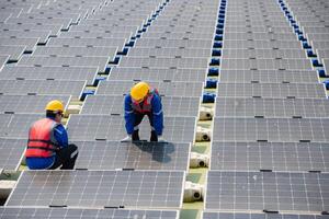 Photovoltaik Ingenieure Arbeit auf schwebend Photovoltaik. prüfen und Reparatur das Solar- Panel Ausrüstung schwebend auf das Wasser. foto