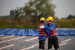 Photovoltaik Ingenieure Arbeit auf schwebend Photovoltaik. prüfen und Reparatur das Solar- Panel Ausrüstung schwebend auf das Wasser. foto