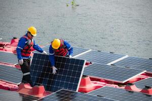 Photovoltaik Ingenieure Arbeit auf schwebend Photovoltaik. prüfen und Reparatur das Solar- Panel Ausrüstung schwebend auf das Wasser. foto